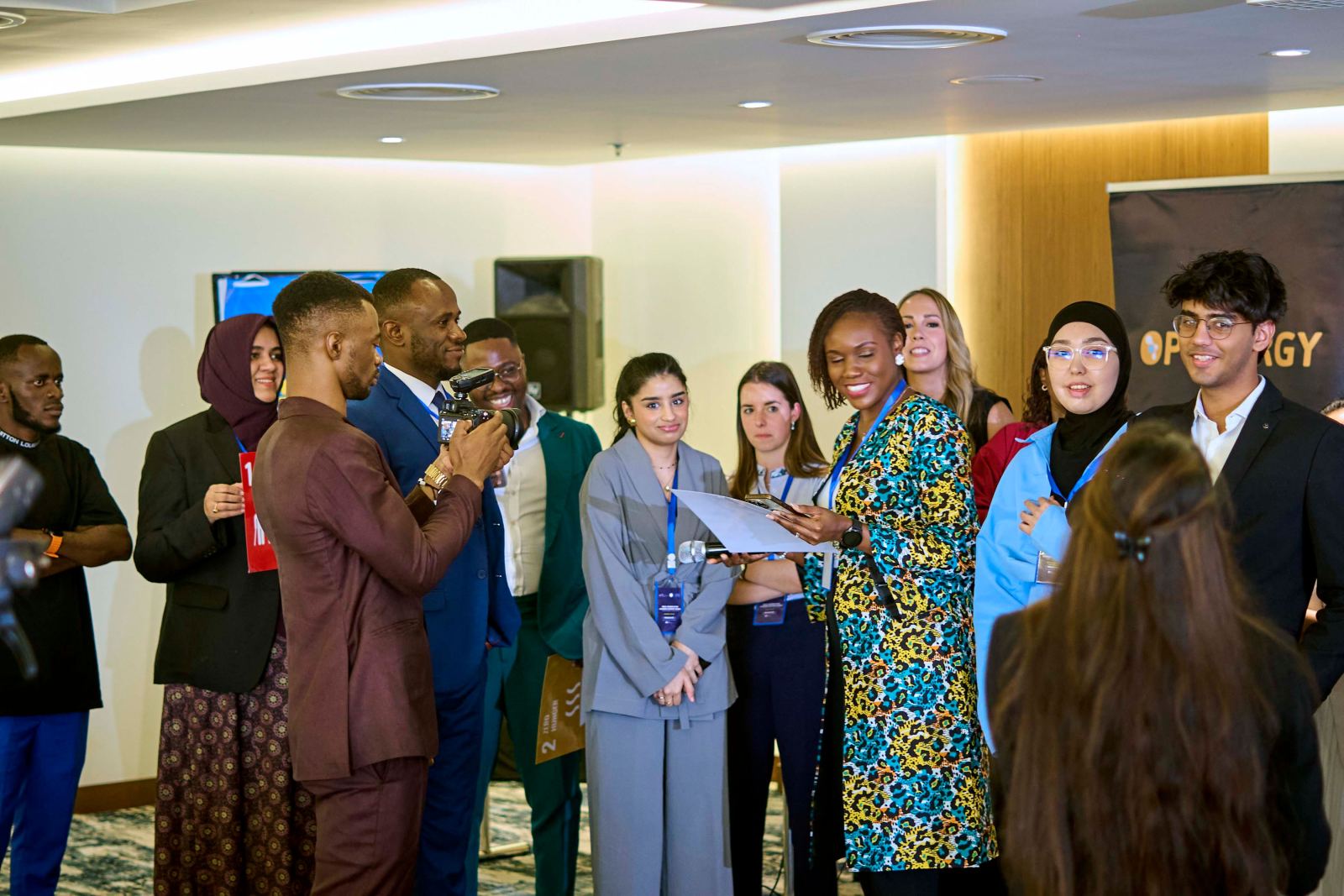 A delegate being interviewed by a group of other delegates holding a microphone